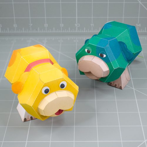 A photo of a papercraft depicting Oatchi and Moss, two space dogs with 2 legs and no nose from the upcoming Pikmin 4 game.