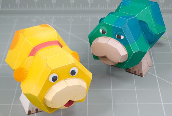 A photo of a papercraft depicting Oatchi and Moss, two space dogs with 2 legs and no nose from the upcoming Pikmin 4 game.