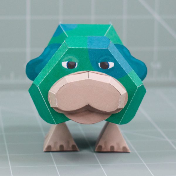 A photo of a papercraft depicting Moss, a green space dog with 2 legs and no nose from the upcoming Pikmin 4 game.