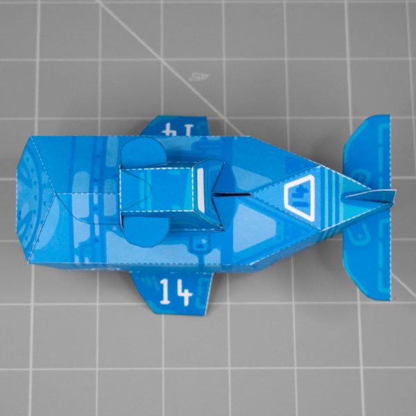 A photo of a papercraft depicting a blue submarine painted to resemble a whale.