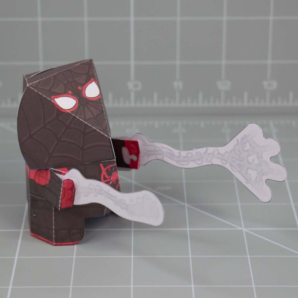 A photo of a Fold Up Friend papertoy of Miles Morales Spider-Man. He has a large round head with a small cute face.