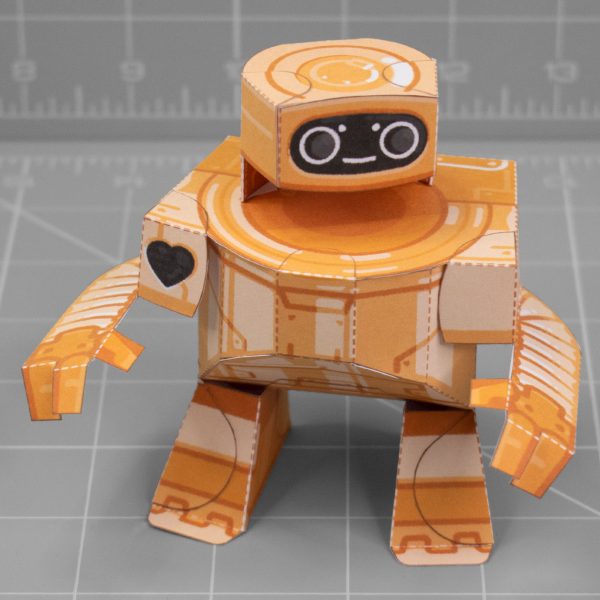 A photo of a papercraft depicting a cute orange robot with large round eyes