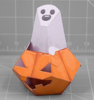 A papercraft of a ghost sitting inside of a Halloween pumpkin
